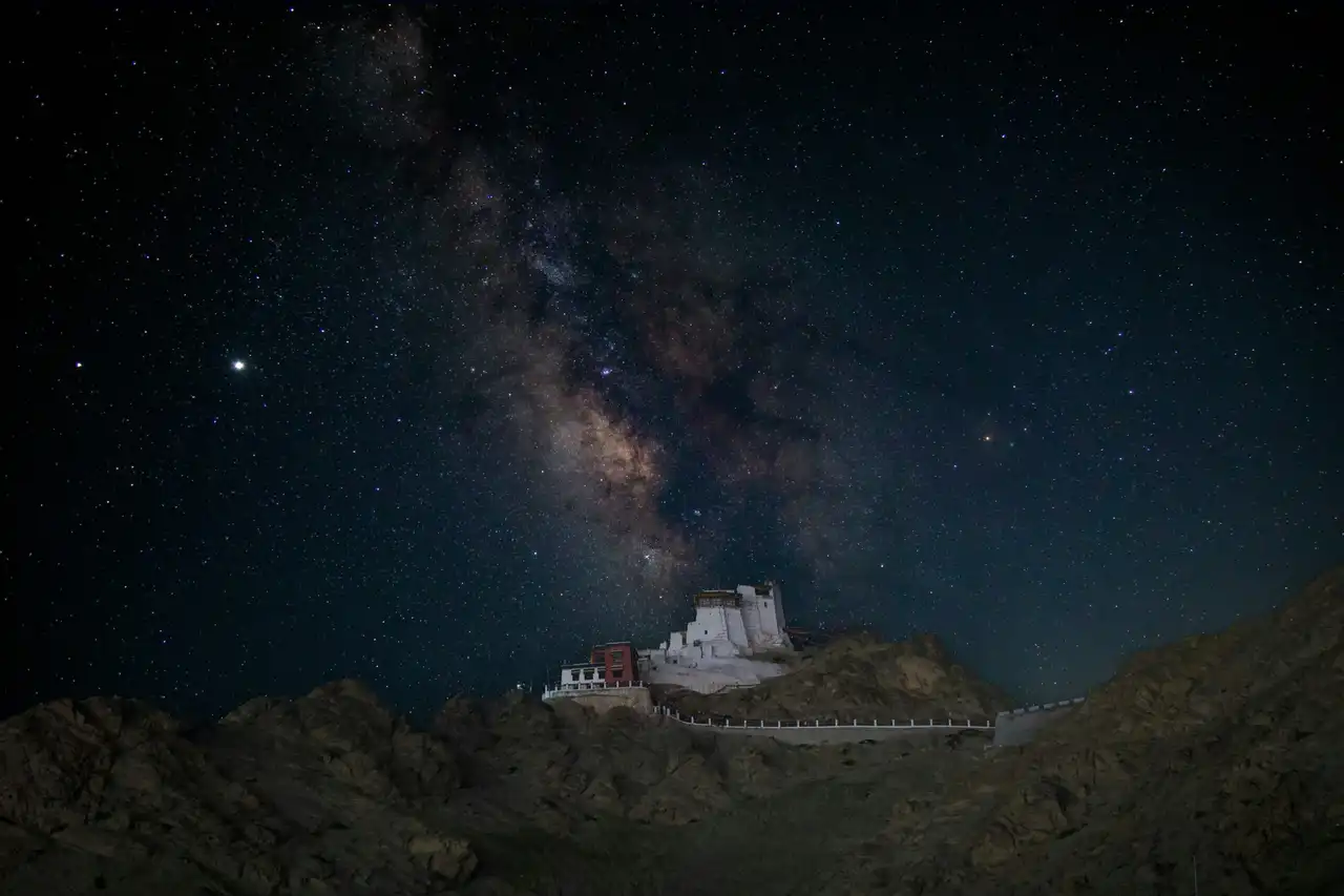 The Milky Way arching over a hilltop monastery in Ladakh