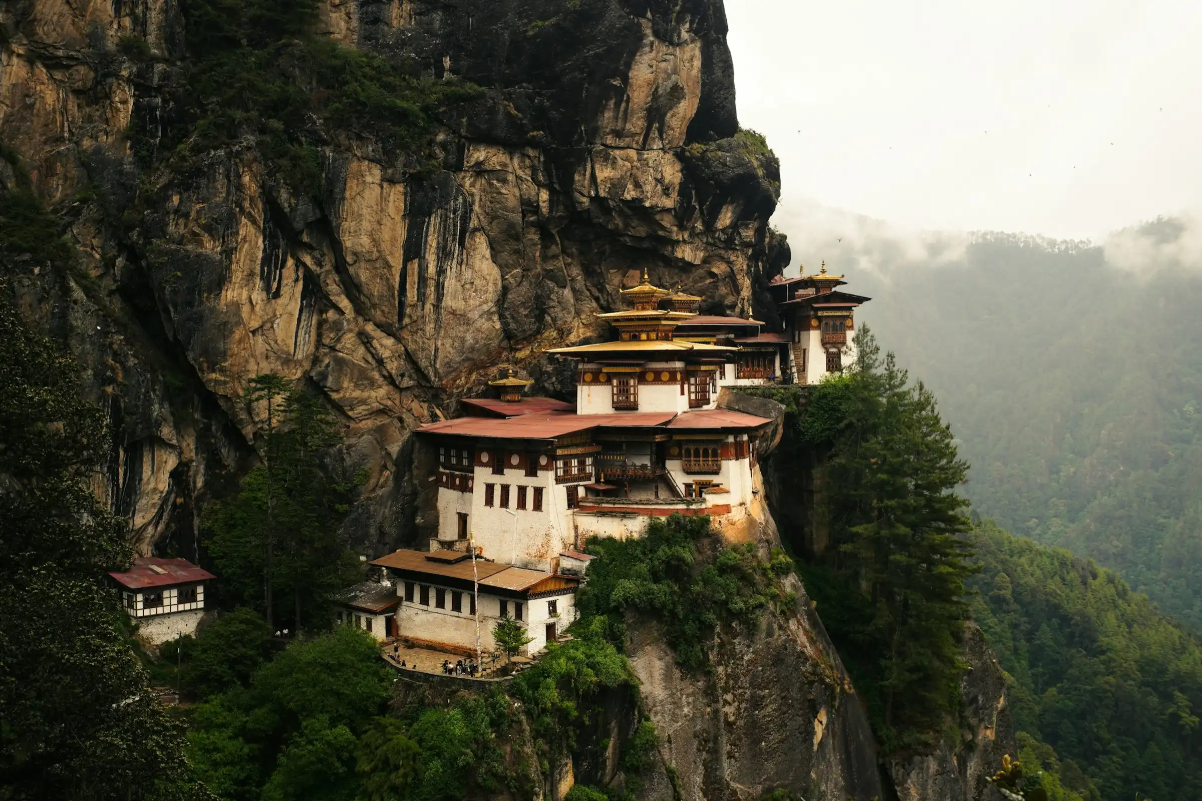 Paro Taktsang monastery on a sheer cliff above forested slopes