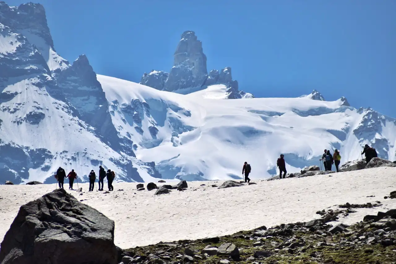 A line of trekkers crossing a snowfield high on the Hampta Pass trek