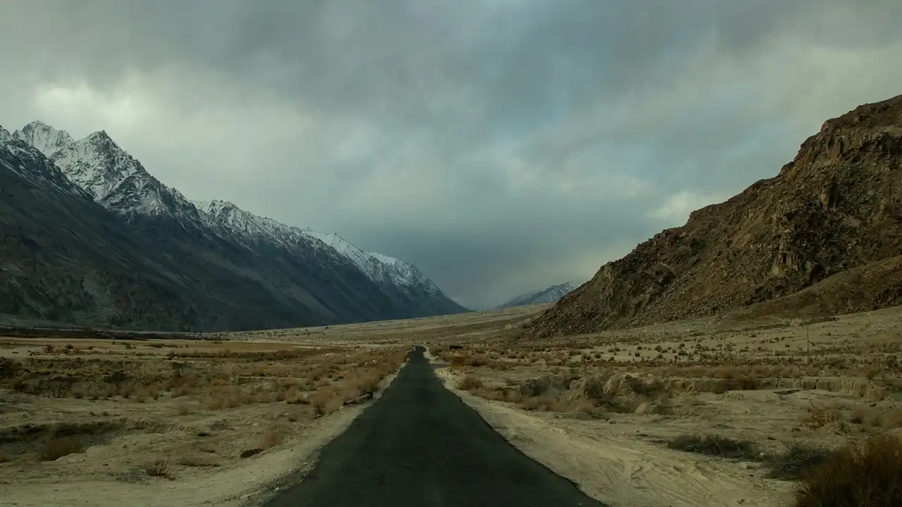 An empty road running through a high desert valley in Ladakh