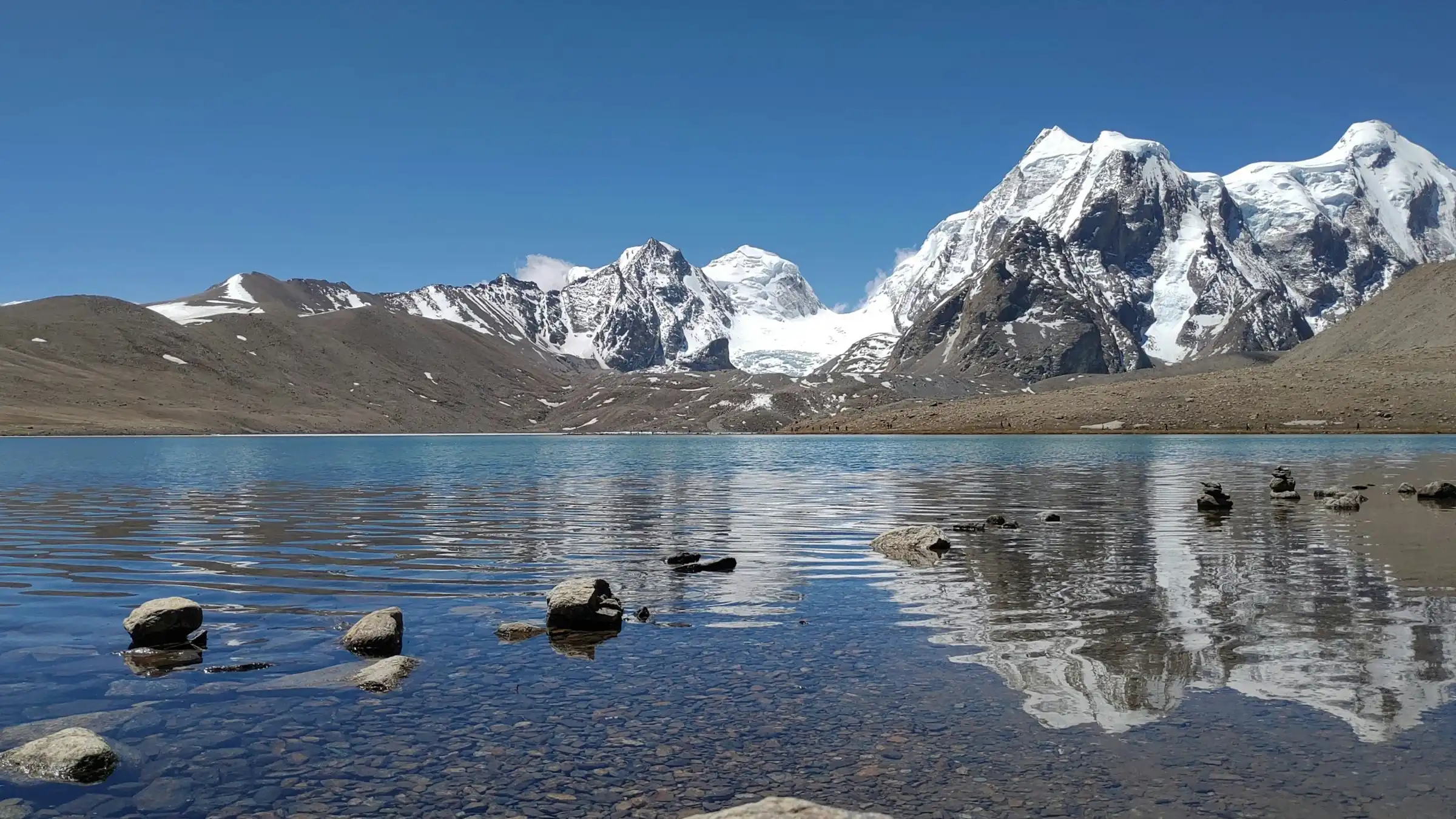 Snow-capped peaks reflected in the still water of Gurudongmar Lake