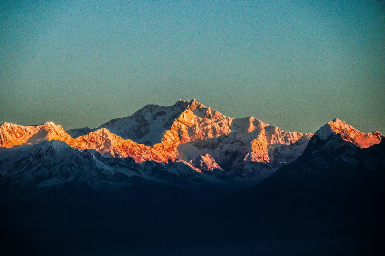 The Kanchenjunga massif lit gold against a teal sky