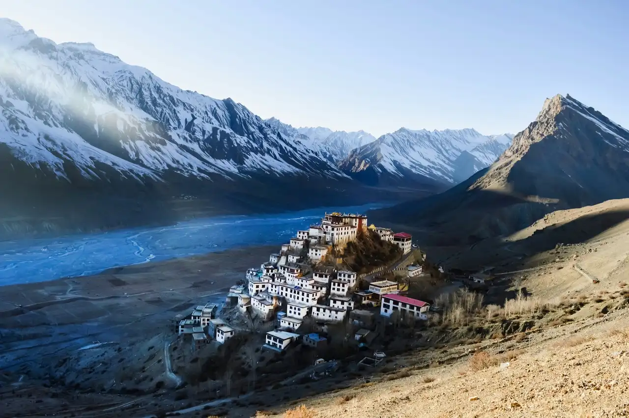 Key Monastery on its hill above the wide Spiti riverbed, with snow-covered peaks behind