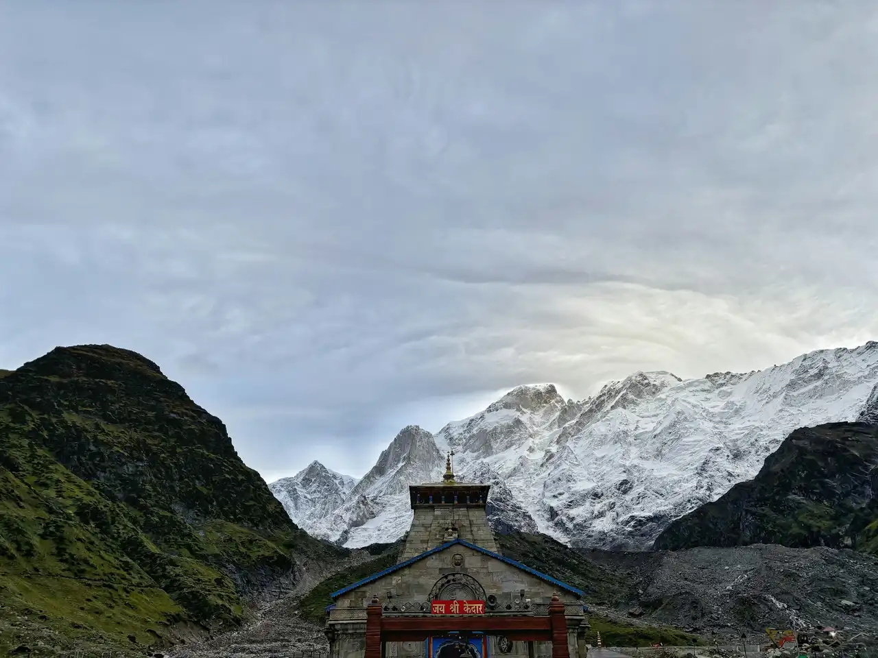 Kedarnath temple beneath a vast sky and snowy peaks